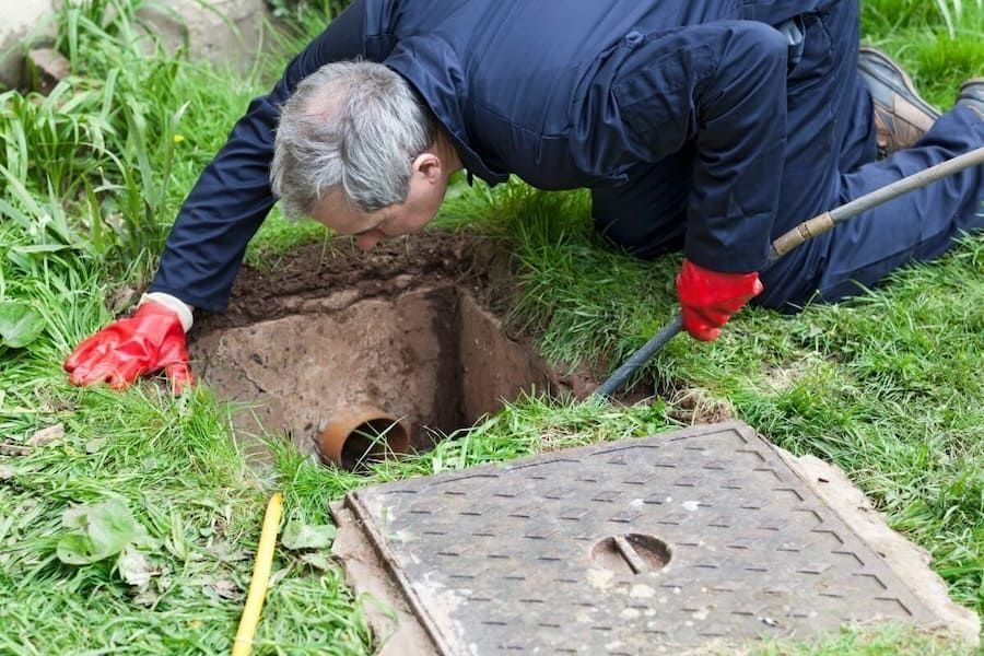 plumber performing a hydro jetting service on a cleanout in someone's yard