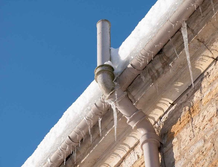 Frozen pipes near the drainage pipe on a house