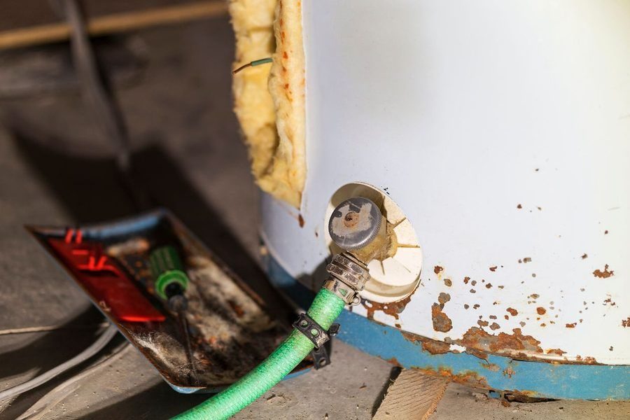 An older, rusty water heater that is in need of repair and maintenance.